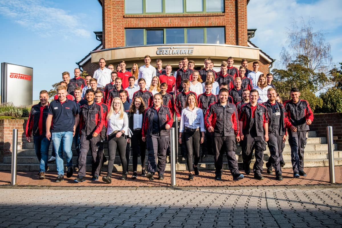Junge Menschen in GRIMME Kleidung auf der Treppe vor dem Verwaltungsgebäude